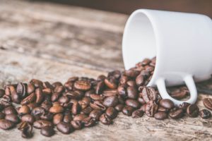 Coffee beans spilling out of a coffee cup