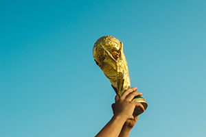 Picture of World Cup trophy held up against clear blue sky